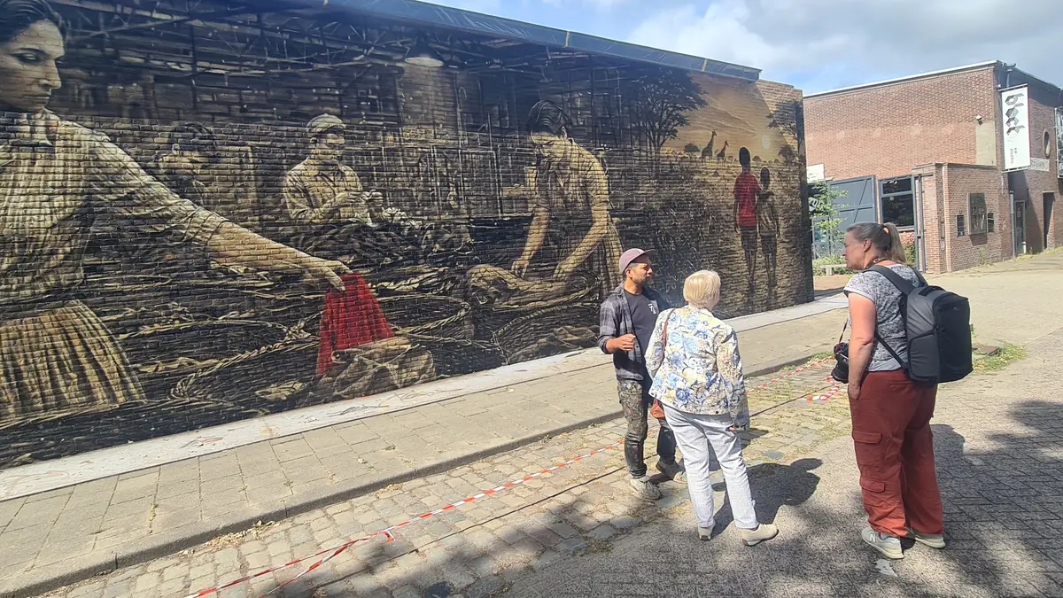 Muurschildering op het terrein met sorteersters aan een tafel